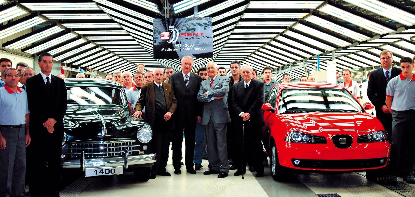 SEAT board members standing with vintage classic SEAT car and SEAT Leon
