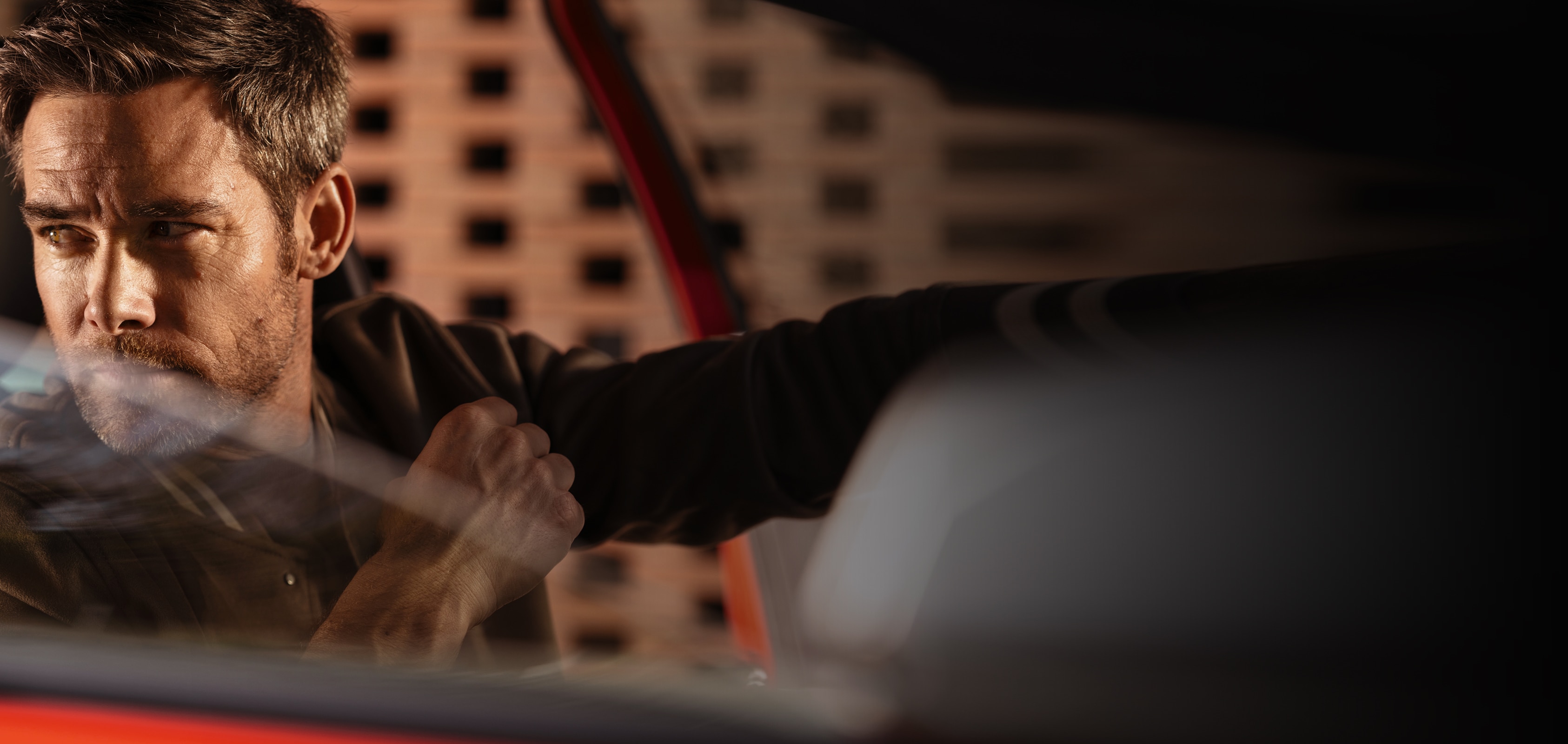 Close up of a man in the driver’s seat of his red SEAT car