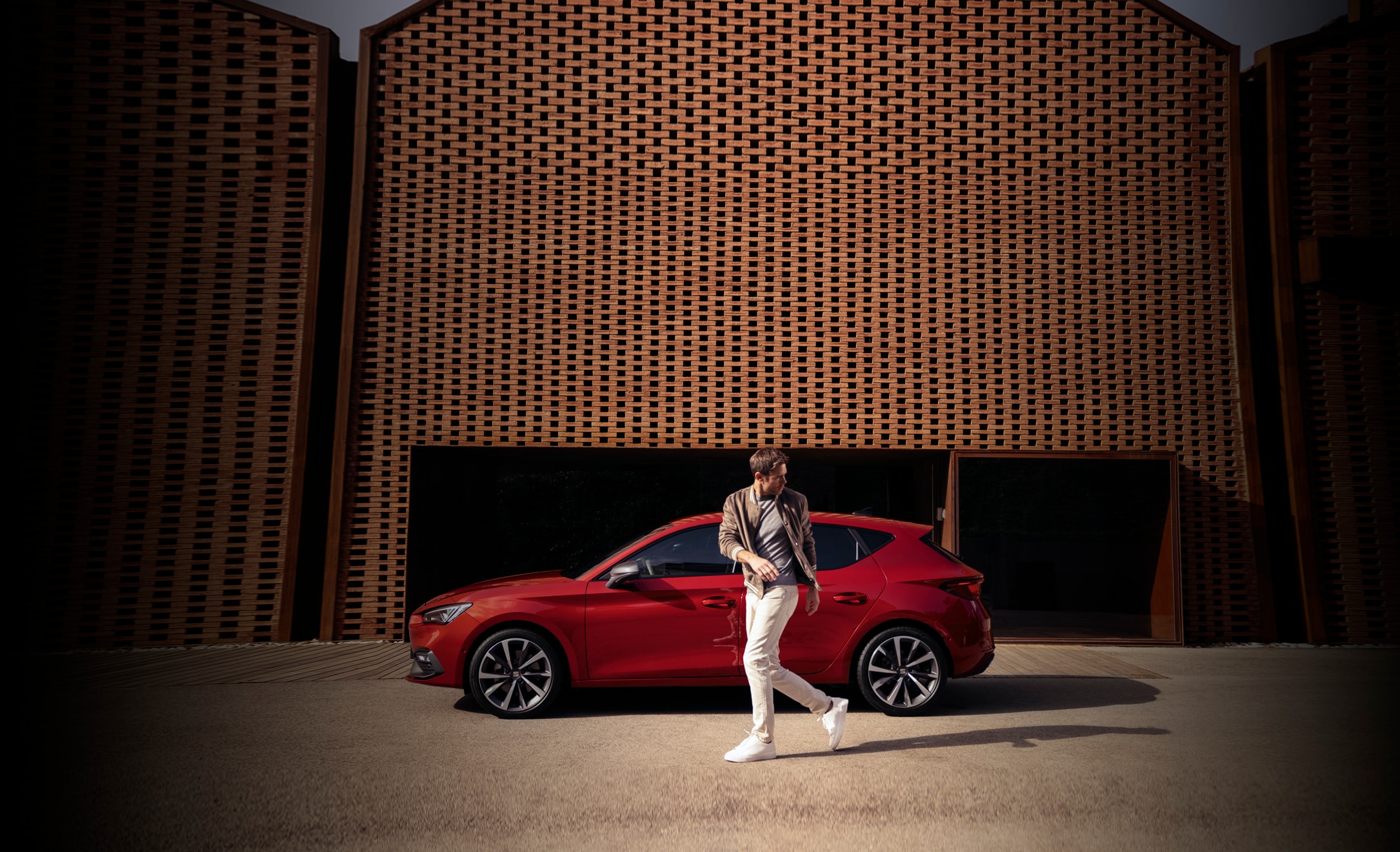 Man walking beside his red SEAT Ibiza car