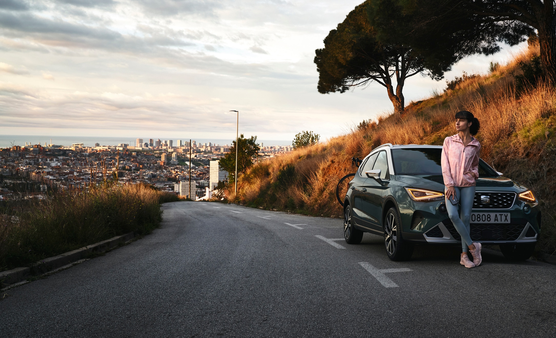 SEAT Ireland personal car leasing woman standing at her new dark camouflage colour SEAT Arona crossover suv