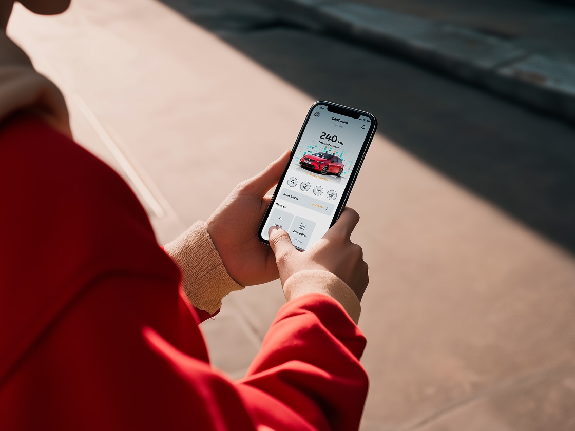 Person holding their smartphone using seat’s remote functions Person holding their smartphone using seat’s remote functions