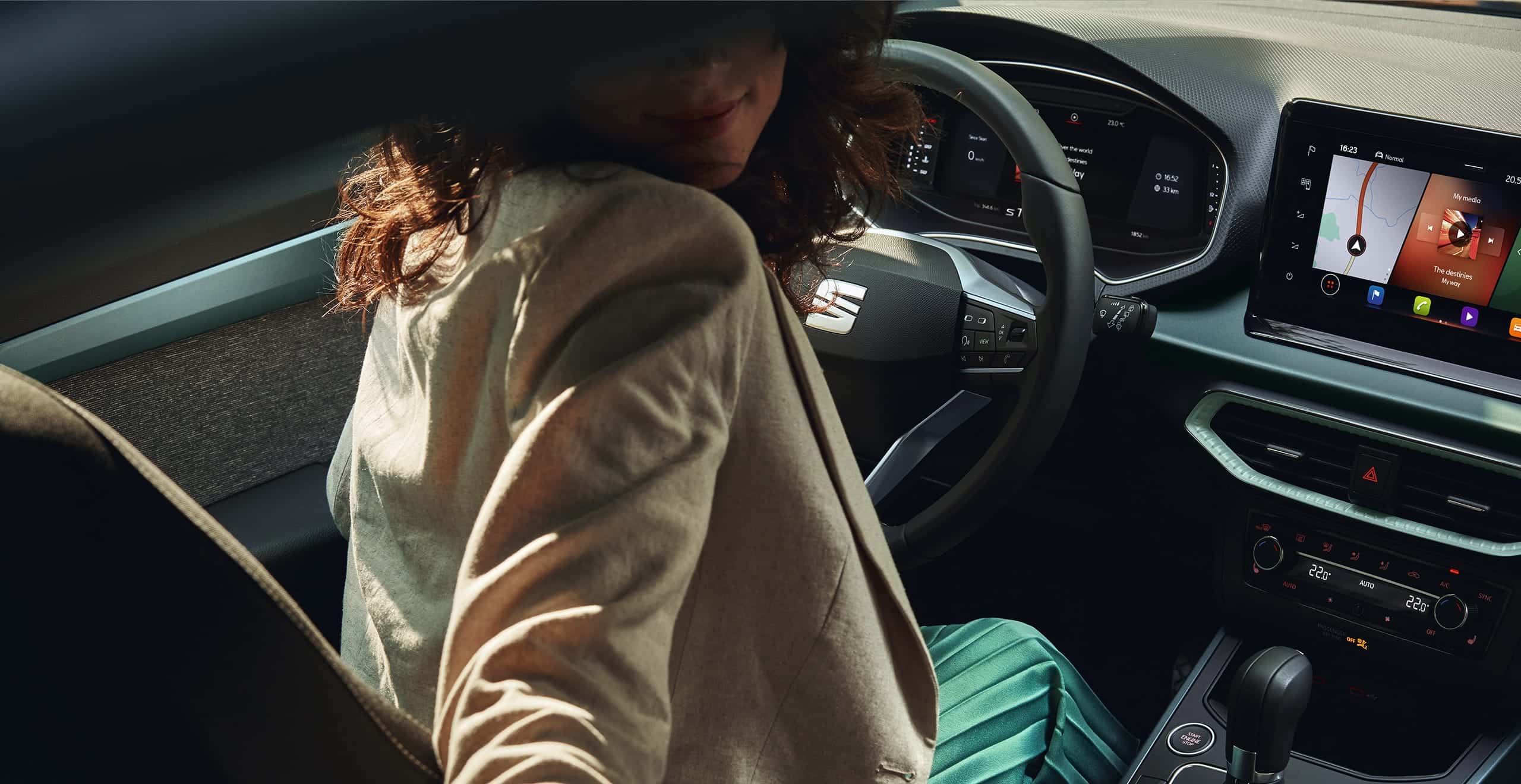 Woman looking back while holding SEAT Arona multifunctional steering wheel