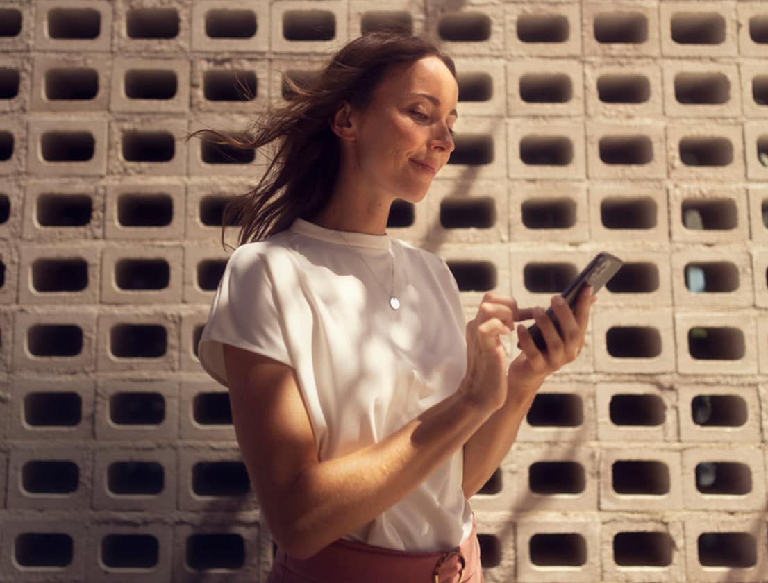 woman looking at her phone using seat connect