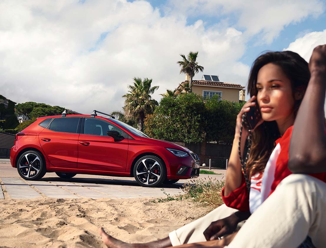 woman talking on the phone with the seat ibiza on the background