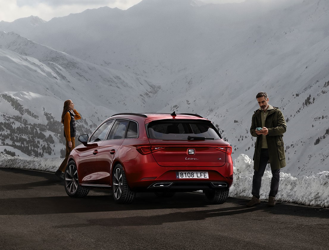 rear view of the desire red SEAT Leon, while couple admiring the mountain