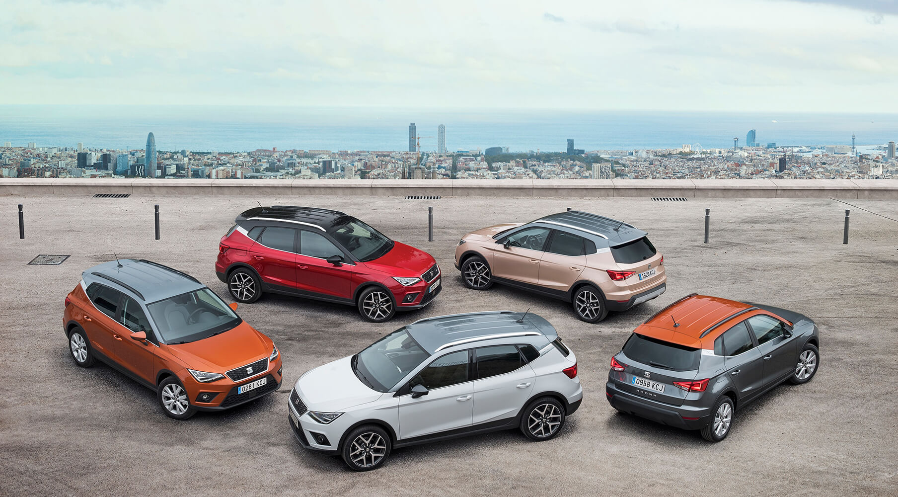 Five SEAT Arona parked with a Barcelona landscape behind