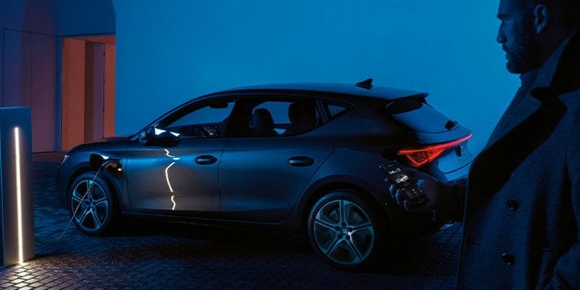 plug in hybrid car with a person nearby, showcasing regenerative braking technology and renewable energy efficiency.