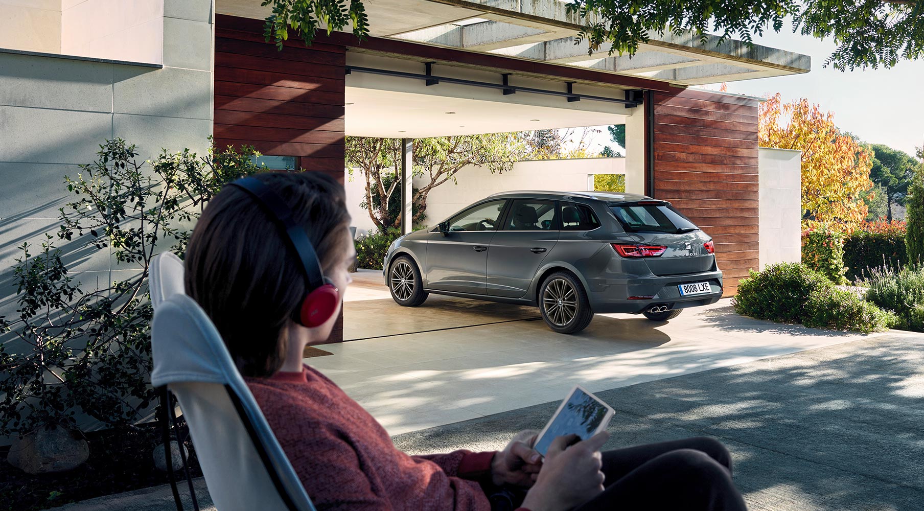 SEAT Leon Sportstourer parked at home with woman watching in a relaxed scene