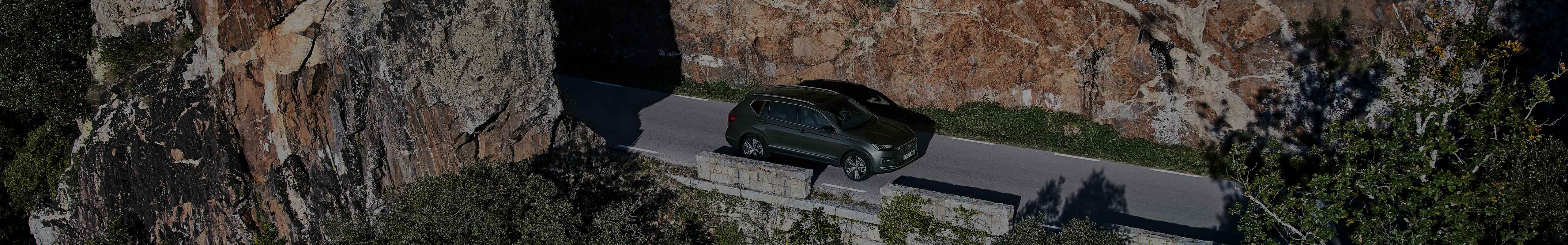 SEAT Tarraco 2021 SUV in dark camouflage colour front side view driving 