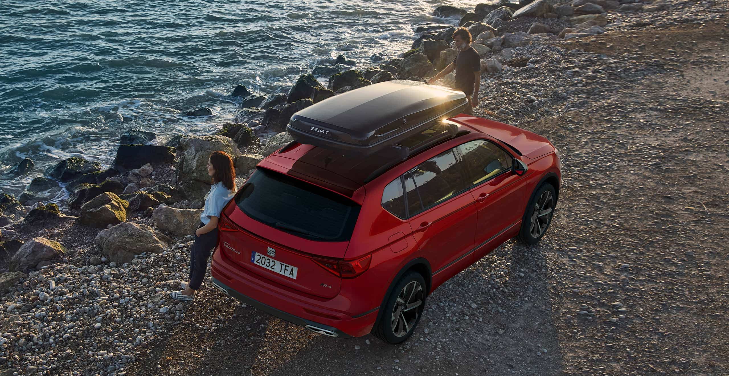 Woman lay on the new SEAT Tarraco SUV 7 seater merlot red colour with a roof box accessory