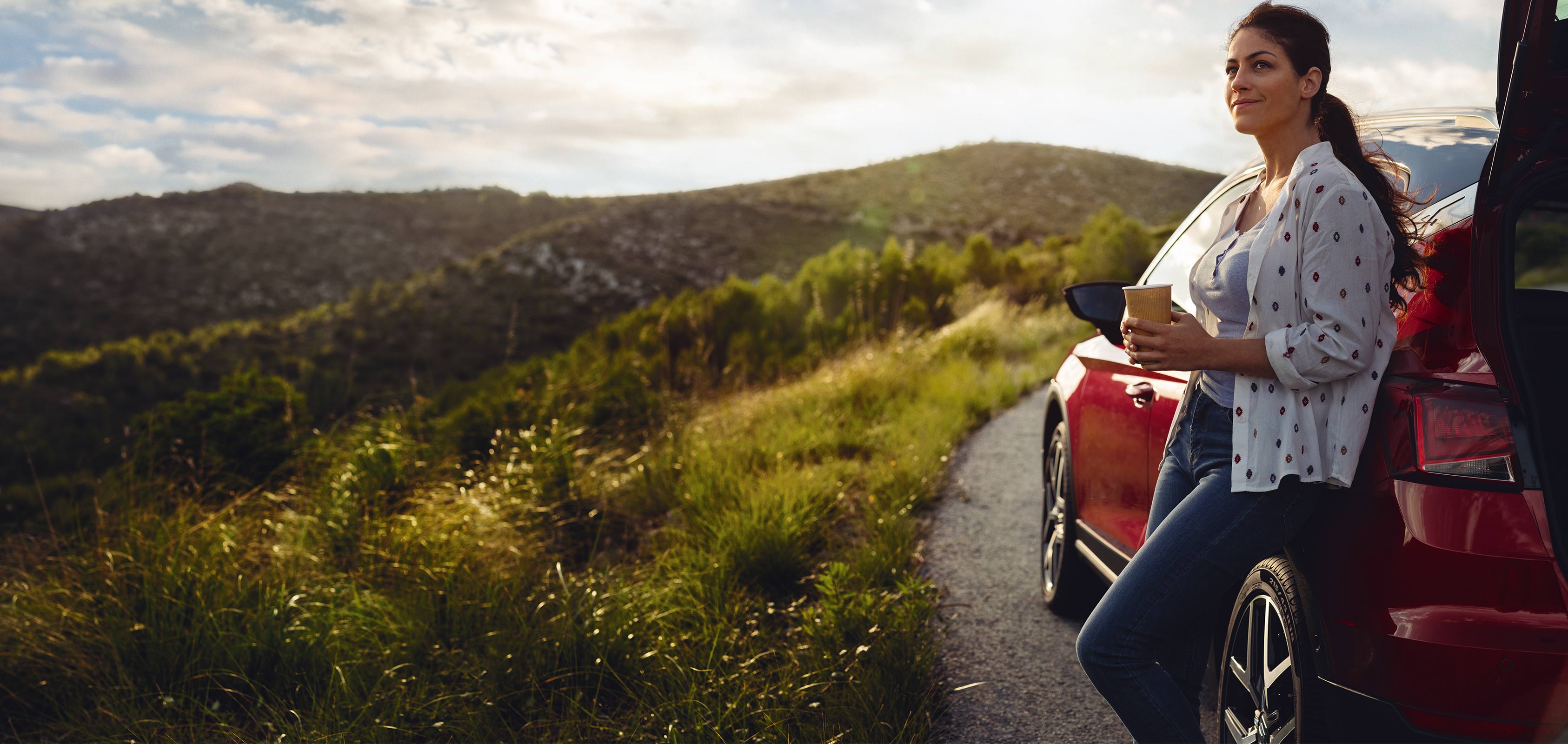 SEAT new car services – Wide shot of woman stepping out of a car hair blowing